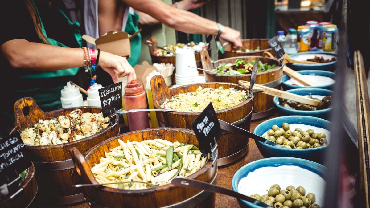 People serving healthy looking food from bowls at a Bristol food market