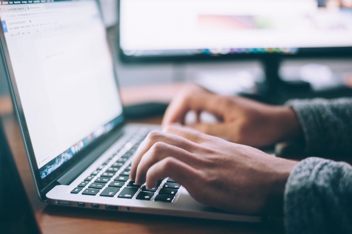 Hands typing at computer
