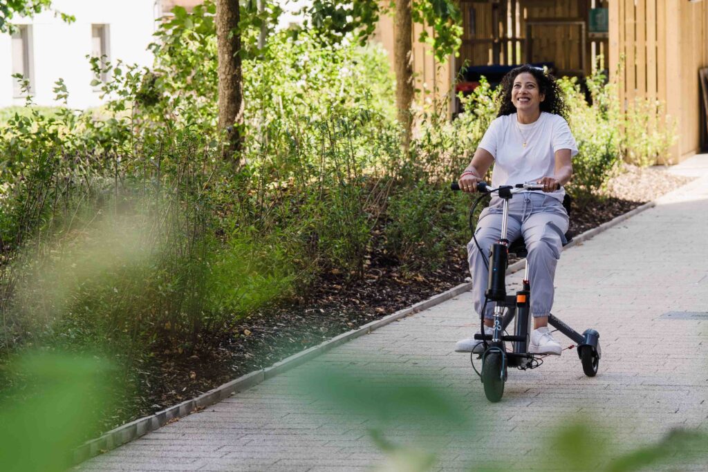 A person joyful as they move quickly along using her Supersmith 3scooter